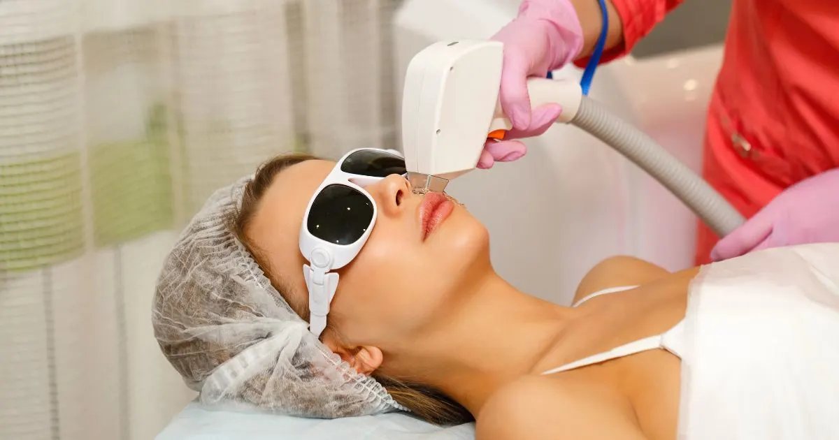 Woman receiving laser hair removal treatment on her upper lip, wearing protective eyewear, at HC Diversified.